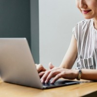 A woman leaves a review on her computer.
