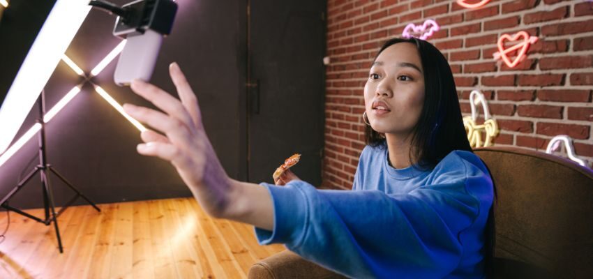 socialMedia-questions-to-ask (2) An influencer prepares before asking engaging questions to their followers in a live setting.