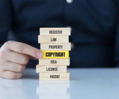 The man holds a wooden block with a keyword relevant to a copyrighted image.