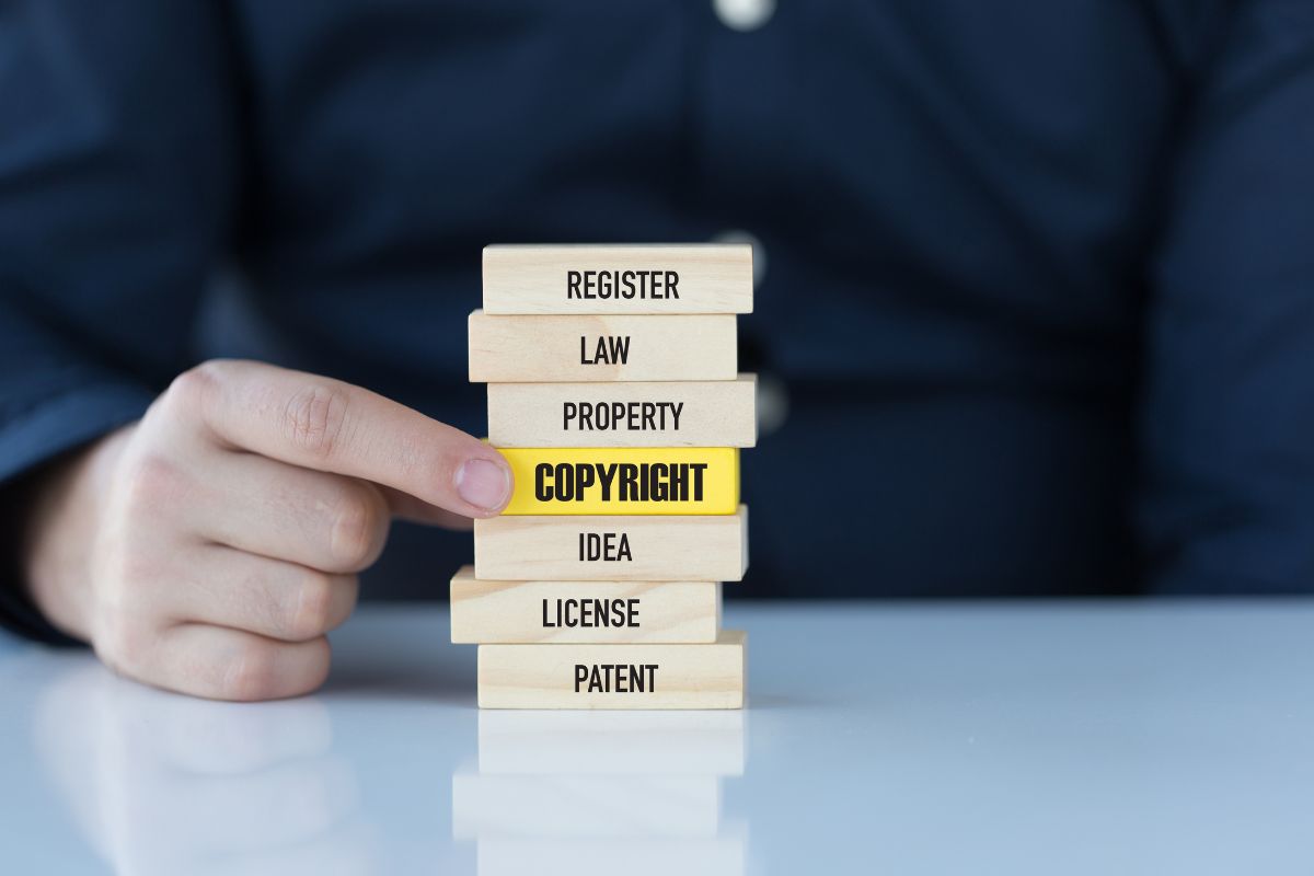 The man holds a wooden block with a keyword relevant to a copyrighted image.