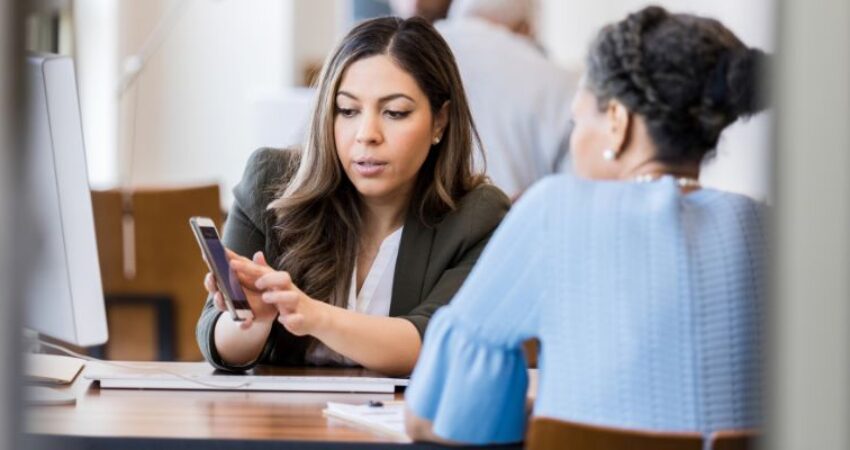 A person who demonstrates SEO for banks to one of his coworkers.