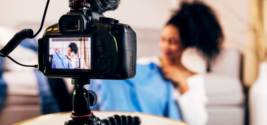 camera capturing video of an influencer showing clothes