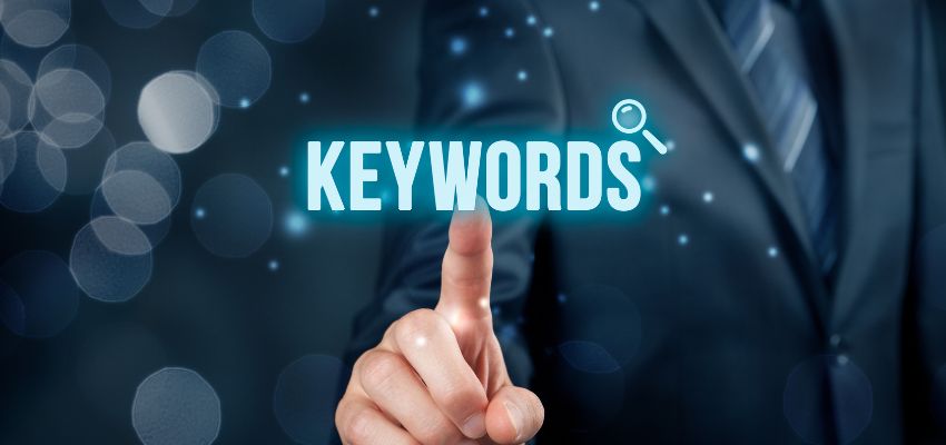 A finger pointing at the word keyword as part of targeted SEO