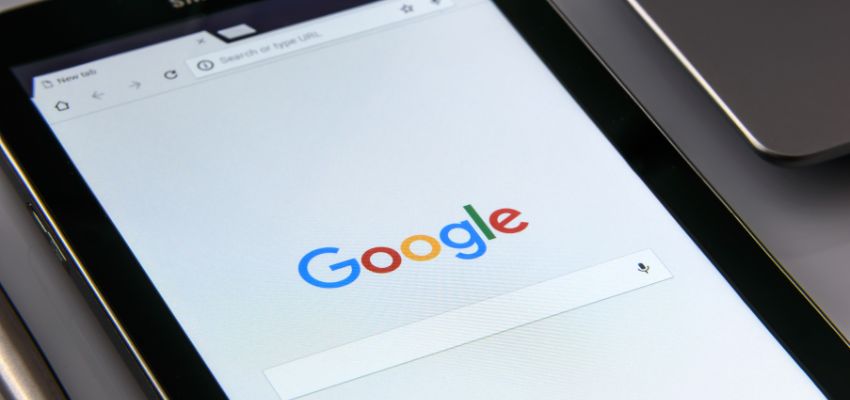 Close-up of a tablet screen showing the Google homepage, representing how technology supports communication within the Google organizational structure.